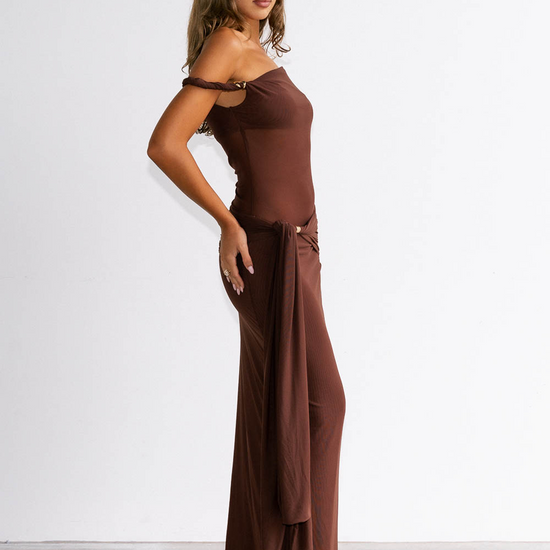 Woman wearing a brown off-shoulder dress against a white background