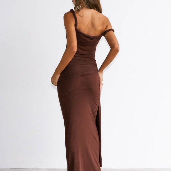 Woman wearing a brown one-shoulder dress with a slit on a white background