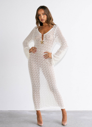 Woman wearing a long, patterned dress against a white background