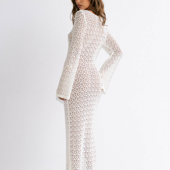 Woman wearing a white dress with a subtle pattern on a plain background