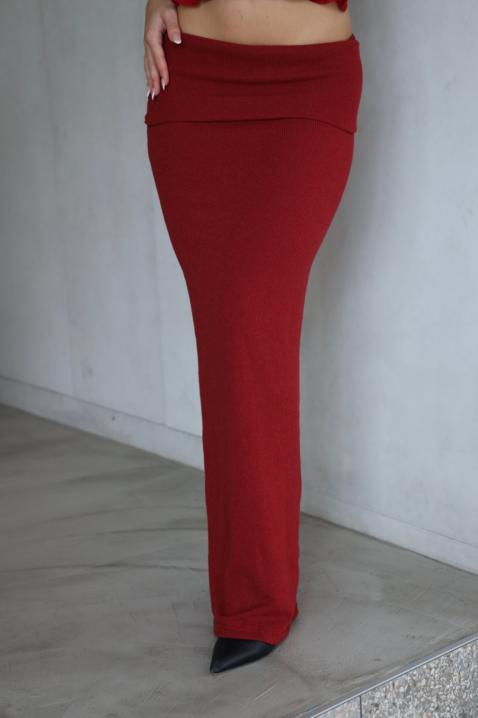 Red skirt worn by a person on a plain background