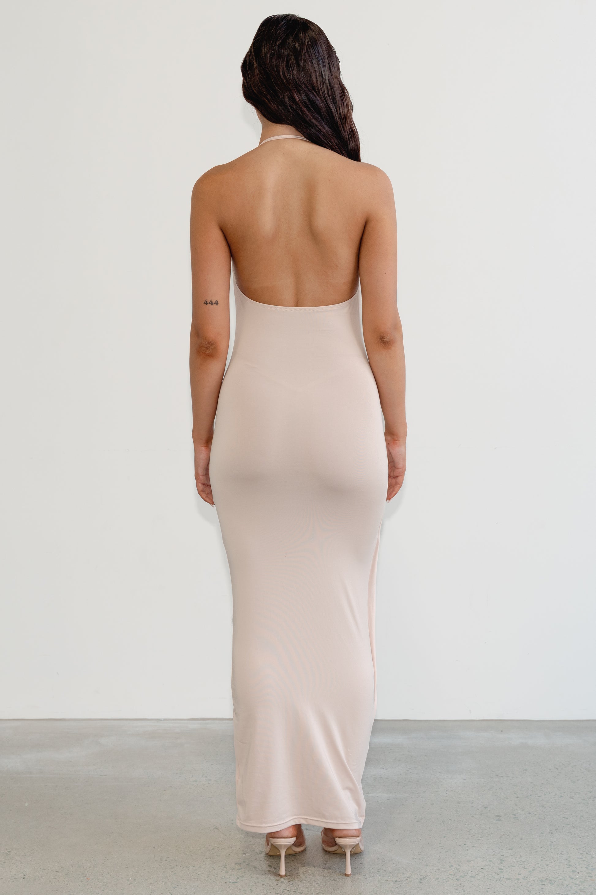 Woman wearing a beige strapless dress with a plain background