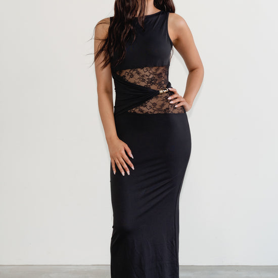 Woman wearing a black sleeveless dress with lace detailing on a white background